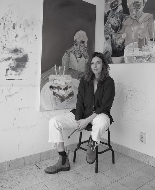 Anastasija Aleksić in her studio, seated in front of her paintings